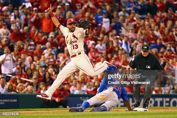 Dexter Fowler of the Chicago Cubs is safe at third base after Matt Carpenter of the St. Louis Cardinals attempts to force him out in the seventh...