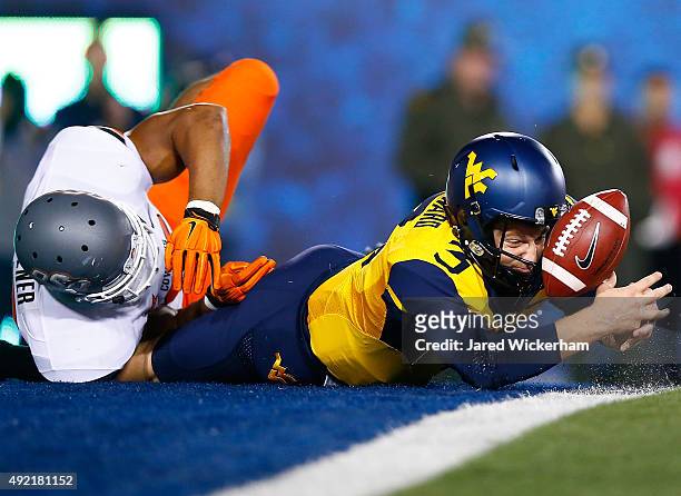 Skyler Howard of the West Virginia Mountaineers fumbles the ball in the endzone in the first half against the Oklahoma State Cowboys during the game...