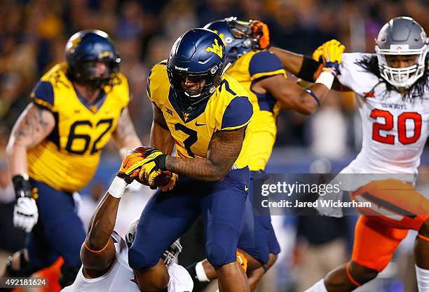 Rushel Shell of the West Virginia Mountaineers has the ball stripped by Emmanuel Ogbah of the Oklahoma State Cowboys before fumbling in the first...