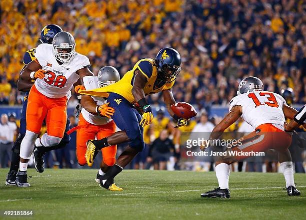 Rushel Shell of the West Virginia Mountaineers fumbles the ball before it is recovered by Jordan Sterns of the Oklahoma State Cowboys in the first...