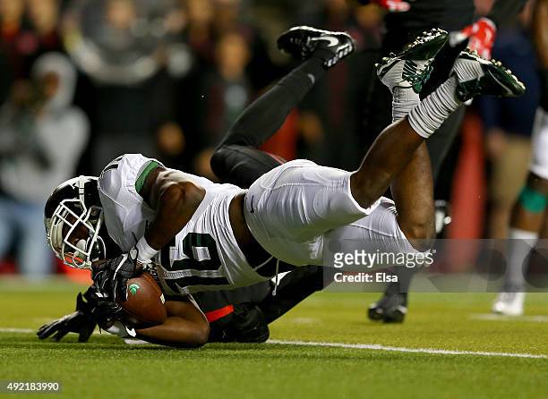 Aaron Burbridge of the Michigan State Spartans makes the catch as Blessuan Austin of the Rutgers Scarlet Knights defends on October 10, 2015 at High...