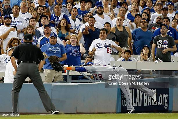 Michael Conforto of the New York Mets is unable to make a catch on a foul ball hit by Yasmani Grandal of the Los Angeles Dodgers in the fourth inning...