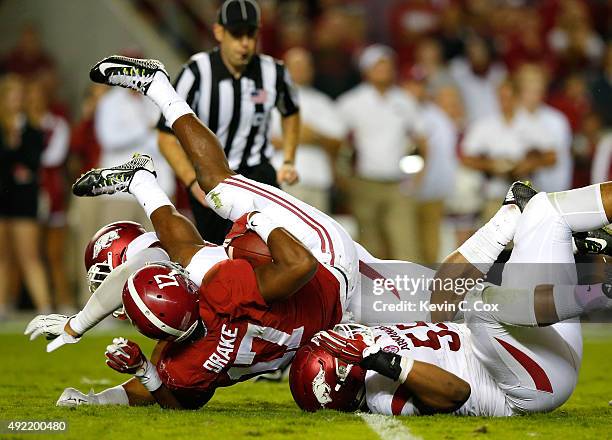 Kenyan Drake of the Alabama Crimson Tide is tackled by Dwayne Eugene and Jeremiah Ledbetter of the Arkansas Razorbacks at Bryant-Denny Stadium on...