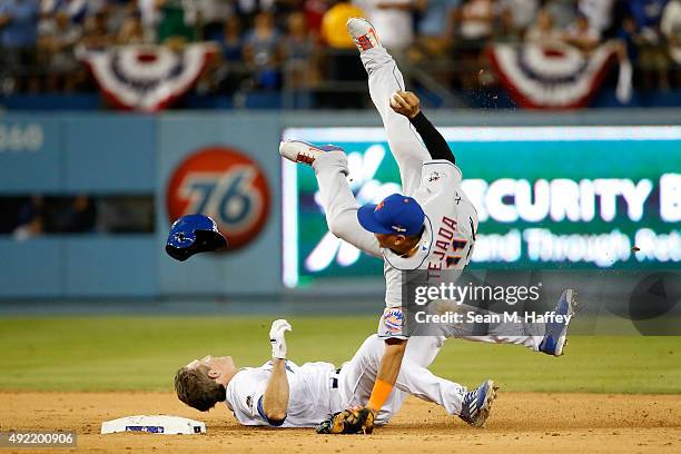 Ruben Tejada of the New York Mets is hit by a slide by Chase Utley of the Los Angeles Dodgers in the seventh inning in an attempt to turn a double...