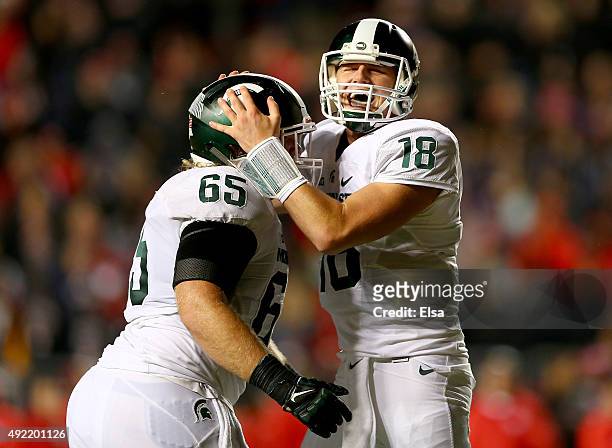 Brian Allen and Connor Cook of the Michigan State Spartans celebrate a touchdown by teammate LJ Scott in the fourth quarter against the Rutgers...
