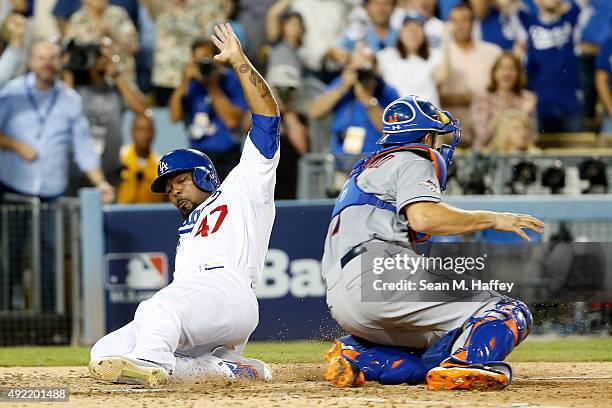 Howie Kendrick of the Los Angeles Dodgers slides home safely to score on a two-RBI double by Adrian Gonzalez of the Los Angeles Dodgers in the...