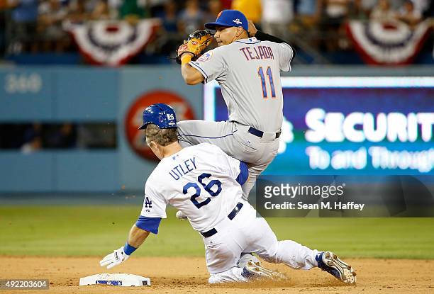 Ruben Tejada of the New York Mets is hit by a slide by Chase Utley of the Los Angeles Dodgers in the seventh inning in an attempt to turn a double...