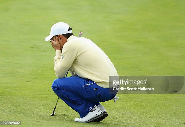 Sang-Moon Bae of the International Team reacts to a poor pitch shot on the 18h hole in his match against Bill Haas of the United States during the...