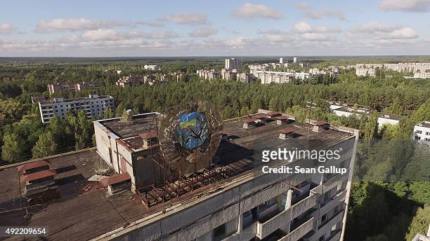In this aerial view a Soviet-era hammer and sickle are adorned with a Ukrainian flag on top of an abandoned apartment building on September 30, 2015...