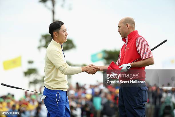 Sang-Moon Bae of the International Team shakes hands with Bill Haas of the United States Team on the 18h green after Haas won the match 2up during...