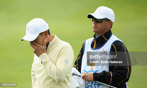 Sang-Moon Bae of the International Team reacts to a poor pitch shot on the 18h hole in his match against Bill Haas of the United States Team as his...