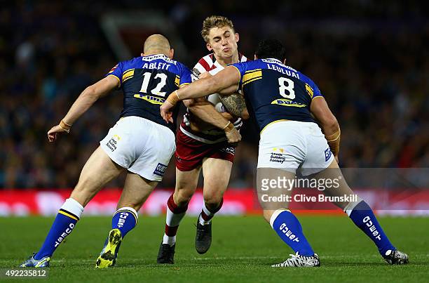 Sam Powell of the Wigan Warriors attempts to move past Carl Ablett and Kylie Leuluai of the Leeds Rhinos during the First Utility Super League Grand...