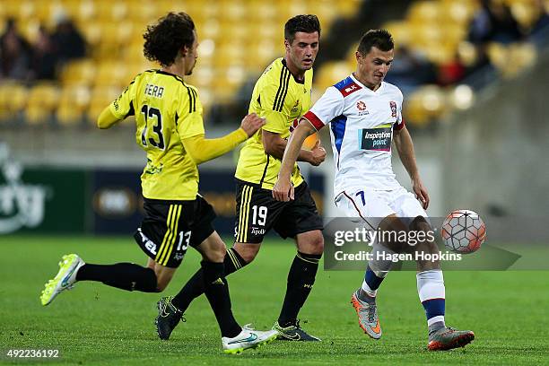 Enver Alivodic of the Jets controls the ball under pressure from Albert Riera and Tom Doyle of the Phoenix during the round one A-League match...