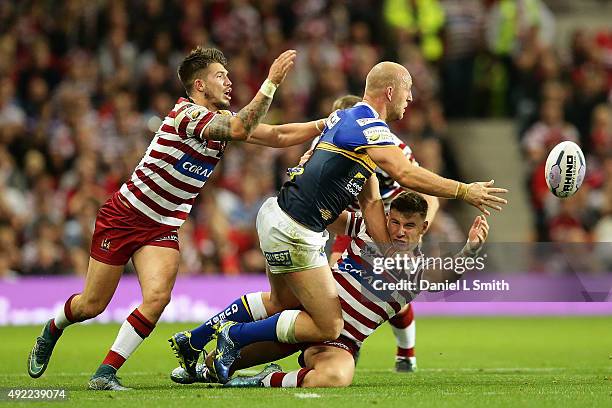 Carl Ablett of Leeds Rhinos disposes of the ball as he pushes George Williams of Wigan Warriors to the ground during the First Utility Super League...