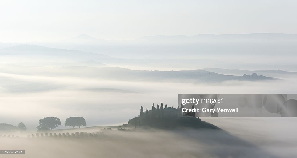 Farmhouse in misty Tuscan landscape