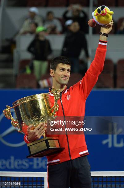 First place winner Novak Djokovic of Serbia poses with the trophy after winning the men's singles final against Rafael Nadal of Spain at the China...