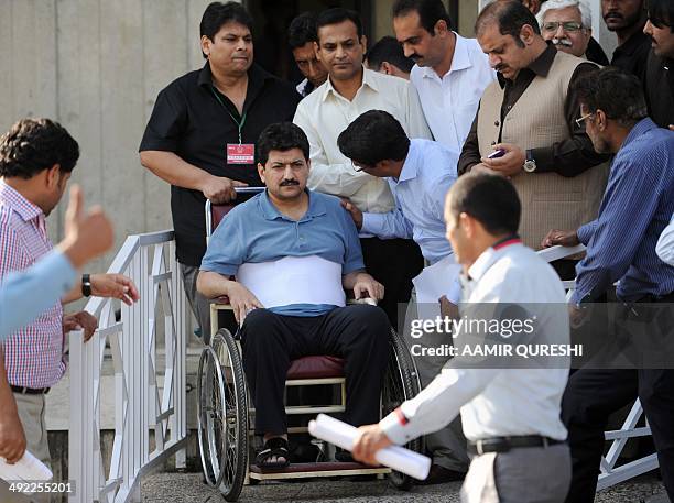 Leading Pakistani TV journalist Hamid Mir, , who survived an April attack by gumen in Karachi, is surrounded by journalists as he leaves the Supreme...