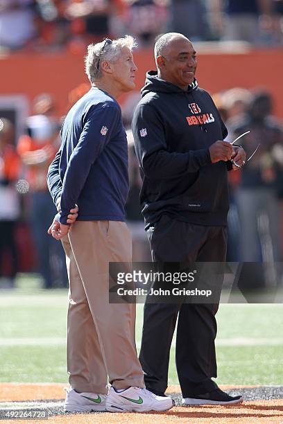 Head Coach Pete Carroll of the Seattle Seahawks and Head Coach Marvin Lewis of the Cincinnati Bengals talk with each other during pre game warmups at...