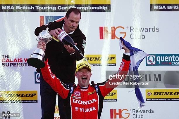 Gordon Shedden of Honda Racing celebrates on the podium after receiving his trophy from BTCC Director Alan Gow for winning the overall championship...