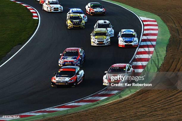 Jason Plato of Team BMR and Matt Neal of Honda Racing drive side by side down Paddock Hill at the start of Race Three of the Final Round of the...