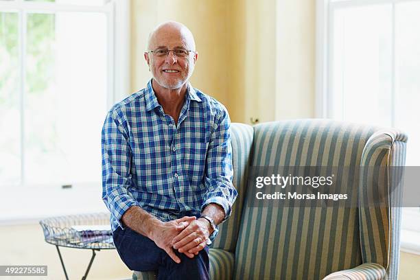 portrait of contented senior man at home - checked shirt stock pictures, royalty-free photos & images