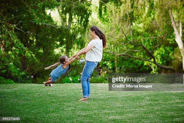 mother and daughter playing in park - children swinging stock pictures, royalty-free photos & images