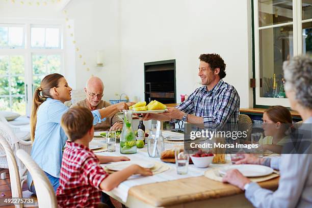 family having meal at dining table - dinner stock-fotos und bilder