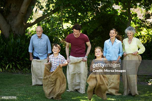 family having sack race in park - sack imagens e fotografias de stock