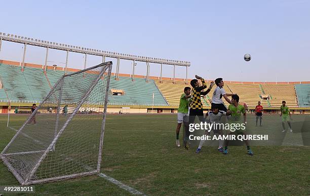 Pakistani street children and local footballers play a friendly match at a stadium in Islamabad on May 19, 2014. In March 2014 a team from Karachi...