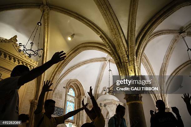 Christian pilgrims from Brazil pray at the Cenacle, or Upper Room on Mount Zion just outside the Old City on May 19, 2014. For Christians, it is the...