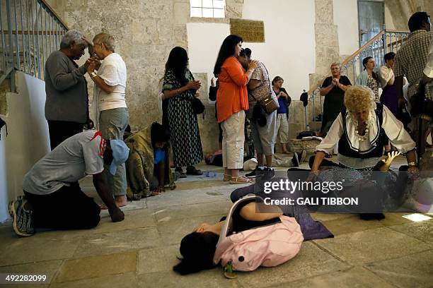 Christian pilgrims from South Africa pray at the Cenacle, or Upper Room on Mount Zion just outside the Old City on May 19, 2014. For Christians, it...