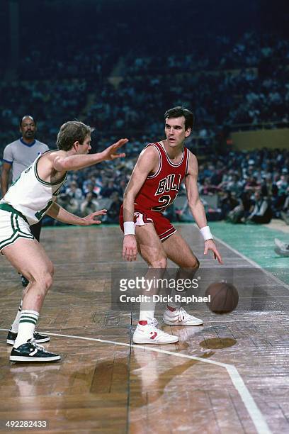 Kyle Macy of the Chicago Bulls dribbles the ball against Jerry Sichting of the Boston Celtics during a game circa 1986 at the Boston Garden in...