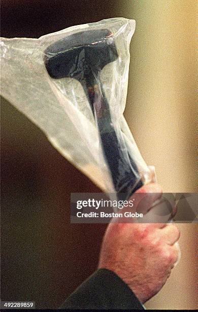 Defense attorney Martin Murphy holds up a hammer, a piece of evidence, during the trial of Dr. Dirk Greineder at Norfolk Superior Court in Dedham,...