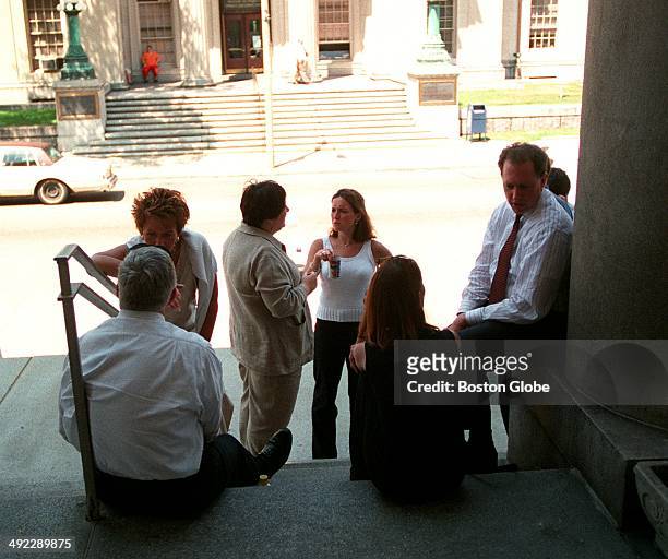 Prosecutor Rick Grundy, right, leaning against column, and others wait outside Norfolk Superior Court as the jury deliberates in the trial of Dr....