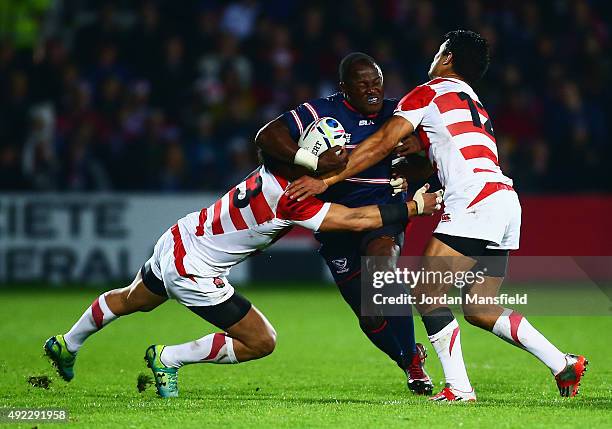 Takudzwa Ngwenya of the United States is tackled by Hiroshi Yamashita and Craig Wing of Japan during the 2015 Rugby World Cup Pool B match between...