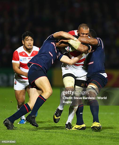 Michael Leitch of Japan is tackled by Kosei Ono of Japan and Michael Broadhurst of Japan during the 2015 Rugby World Cup Pool B match between USA and...