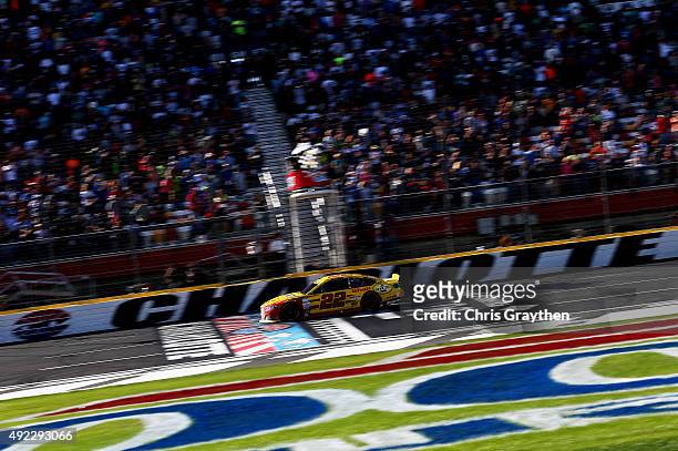Joey Logano, driver of the Shell Pennzoil Ford, crosses the finish line to win the NASCAR Sprint Cup Series Bank of America 500 at Charlotte Motor...