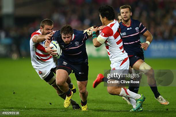 Zach Fenoglio of the United States is tackled by Michael Broadhurst and Harumichi Tatekawa of Japan during the 2015 Rugby World Cup Pool B match...