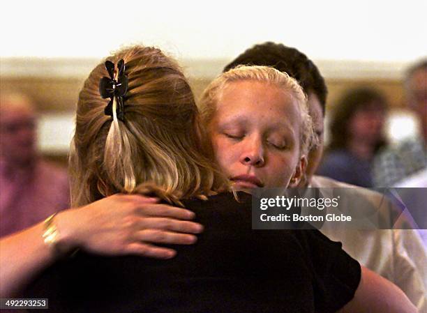 Britt Greineder hugs her sister, Kirsten Greineder, back to camera, during a break in the trial of their father, Dr. Dirk Greineder, at Norfolk...