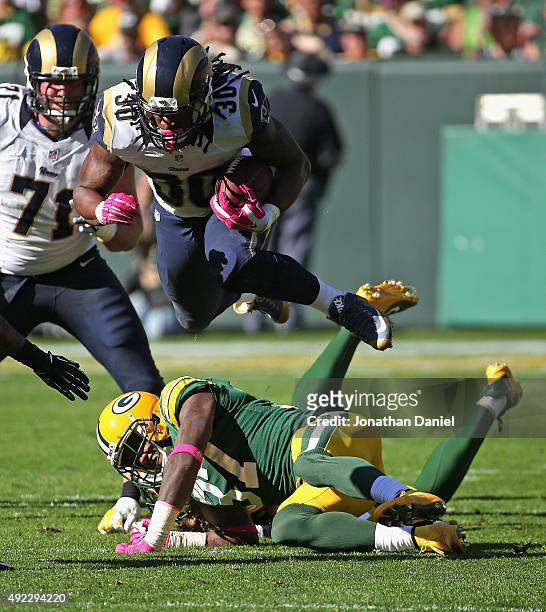 Todd Gurley of the St. Louis Rams leaps over Sam Shields and Clay Matthews of the Green Bay Packers at Lambeau Field on October 11, 2015 in Green...