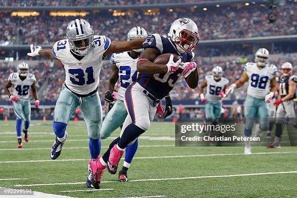 Running back Dion Lewis of the New England Patriots carries the ball as cornerback Byron Jones of the Dallas Cowboys tries to make the tackle during...