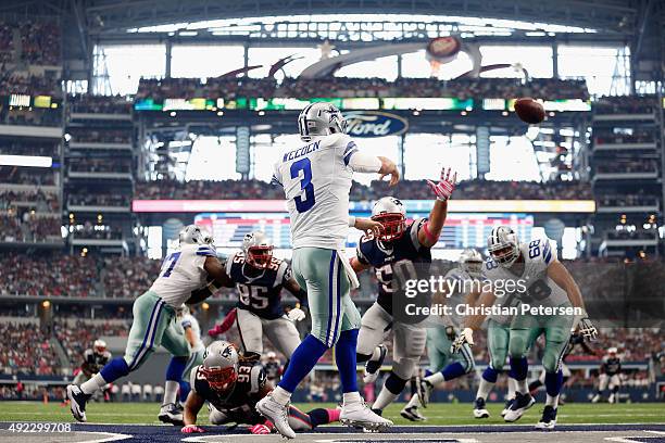 Quarterback Brandon Weeden of the Dallas Cowboys passes from the end zone as defensive end Rob Ninkovich of the New England Patriots applies pressure...