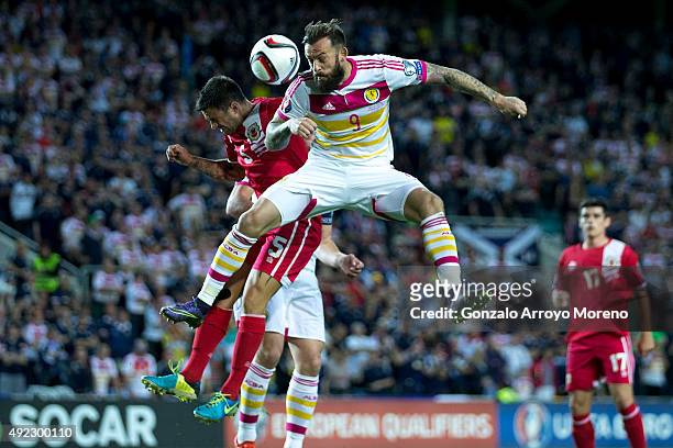 Steven Fletcher of Scotland wins the header after Ryan Casciaro of Gibraltar during the UEFA EURO 2016 Qualifying round Group G match between...