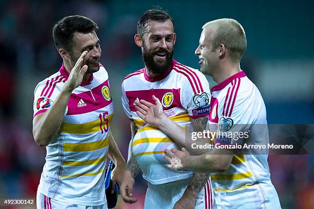 Steven Fletcher of Scotland celebrates their victory with teammates Russell Martin and Steven Naismith after winning the UEFA EURO 2016 Qualifying...