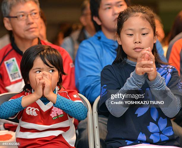 Japanese girls mimic the pose of Japanese full back Ayumu Goromaru's goal kick during a public viewing of the Rugby World Cup match against the...