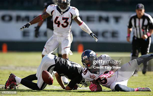 David Bruton of the Denver Broncos forces a fumble from Seth Roberts of the Oakland Raiders in the fourth quarter at O.co Coliseum on October 11,...