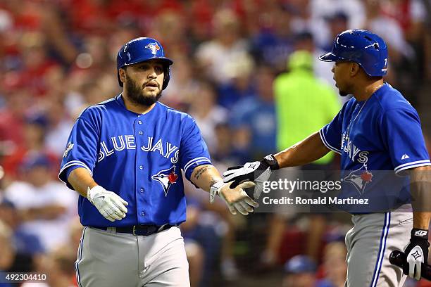 Dioner Navarro of the Toronto Blue Jays celebrates with Ben Revere after scoring a run off Ryan Goins against Martin Perez of the Texas Rangers...