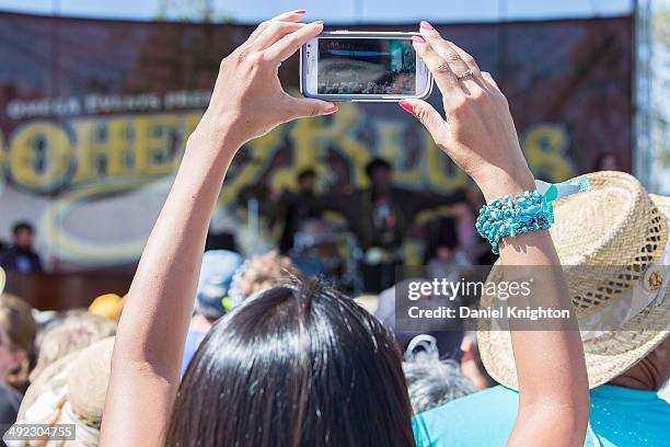 Fan takes a picture with her cell phone during a performance by Charles Bradley & The Extraordinaires at Doheny State Beach on May 18, 2014 in Dana...