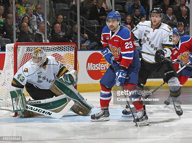 Mitchell Moroz of the Edmonton Oil Kings watches for a pass between Anthony Stolarz and Brady Austin of the London Knights in Game Three of the 2014...
