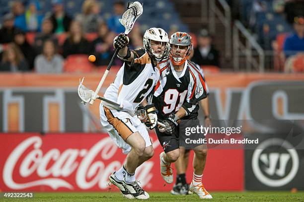 Dave Lawson of the Rochester Rattlers is defended by Dillon Roy of the Denver Outlaws during a Major League Lacrosse game at Sports Authority Field...